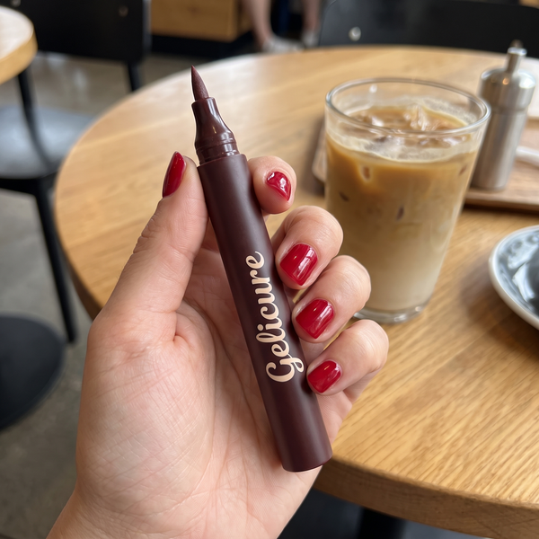 Cherry red nails holding the Gelicure pen