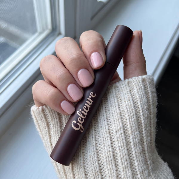 Pastel pink nails holding the Gelicure pen