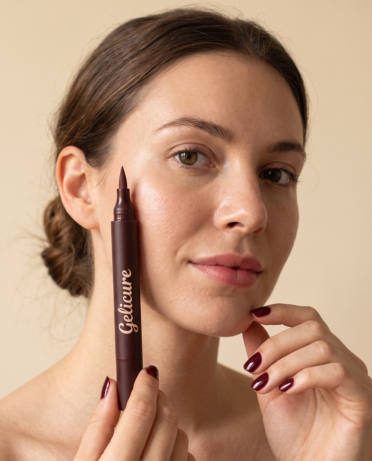 Woman holding the Gelicure pen next to her face