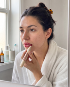 Applying the Gelicure Lip Pen in the mirror